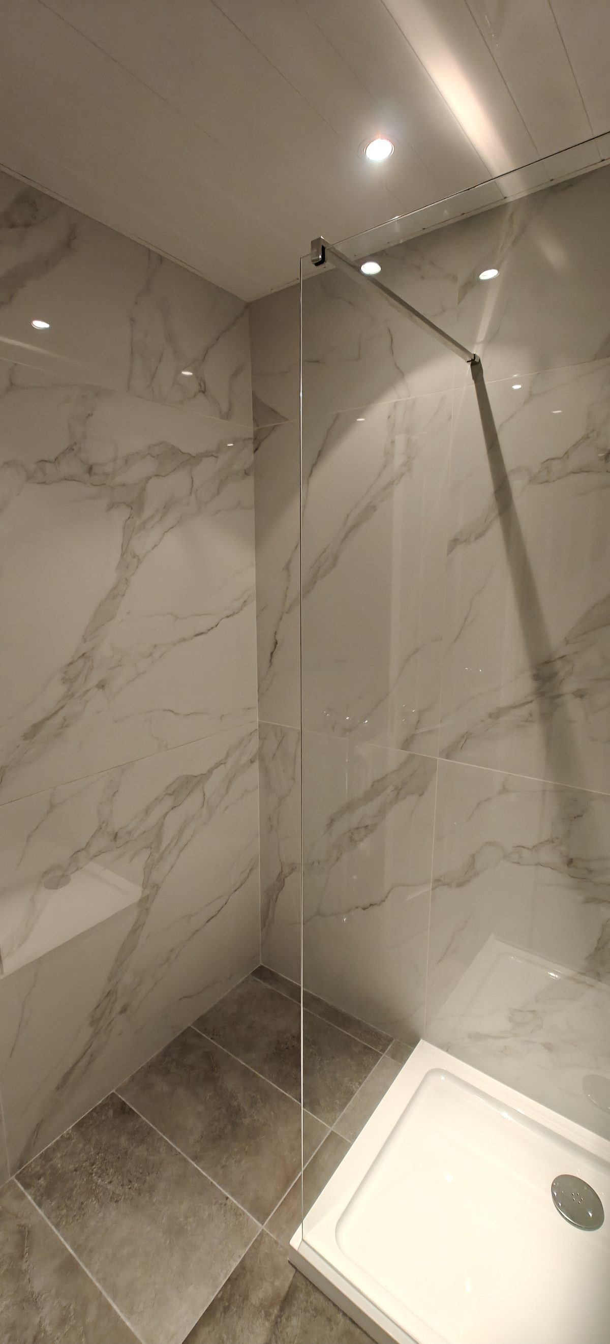 Shower tray and glass screen in a marble effect bathroom