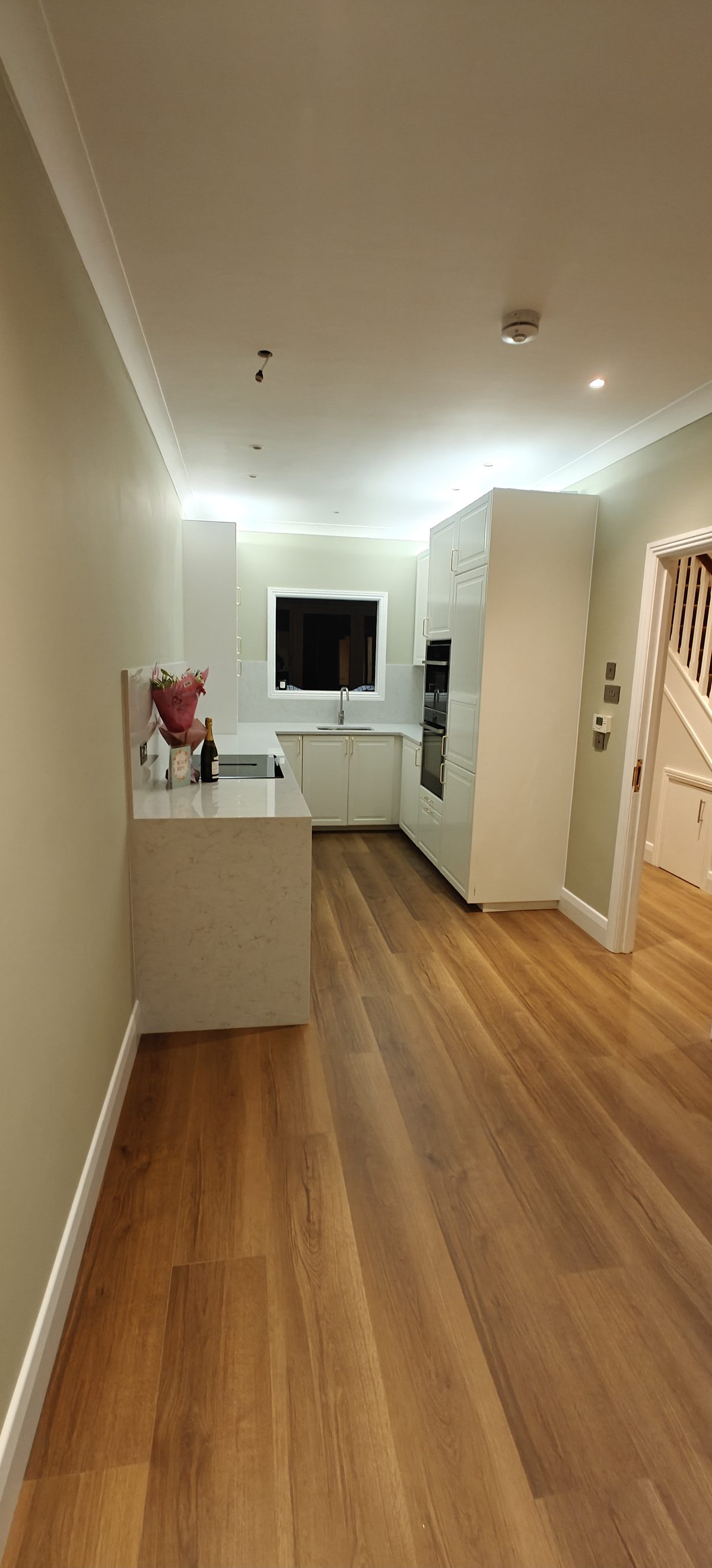 Cream kitchen with a quartz worktop and oak floor